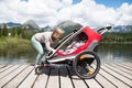 Senior woman and children in jogging stroller, summer day. Royalty Free Stock Photo