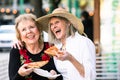 Senior Women Eating Street Food and Laughing