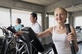 Senior woman exercising spinning bike in fitness gym. elderly healthy lifestyle concept Royalty Free Stock Photo