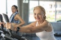 Senior woman exercising spinning bike in fitness gym. elderly healthy lifestyle concept Royalty Free Stock Photo