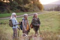 Senior women friends with dog on walk outdoors in nature.