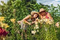 Senior woman and her daughter gathering flowers in garden. Gardeners cutting lilies off with pruner. Gardening concept