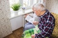 Woman holding cash in front of heating radiator. Payment for heating in winter. Selective focus.