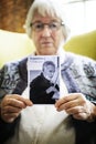 Senior woman holding a photo of a senior man Royalty Free Stock Photo