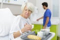 senior woman in hospital disliking medical center meal