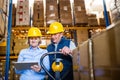 Senior woman manager and man worker with tablet working in a warehouse. Royalty Free Stock Photo
