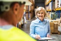 Senior woman manager and man worker working in a warehouse. Royalty Free Stock Photo