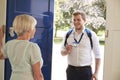 Senior woman opens door to male care worker showing his ID Royalty Free Stock Photo