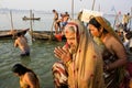Senior women praying in crowd on the river banks