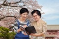 Senior woman reading a travel guidebook with her daughter