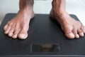 senior women& x27;s feet on weight scale close up.