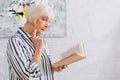 Senior woman in striped shirt reading