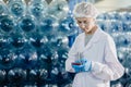 Senior women worker work in drink water factory counting check water bottle gallon stock in hygiene uniform workplace Royalty Free Stock Photo