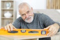 Senior wood measuring with spirit level Royalty Free Stock Photo