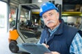 Senior worker with clipboard working on forklift Royalty Free Stock Photo