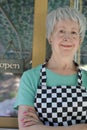 Senior worker outside business with open sign