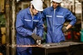 Senior worker training and watch new young trainee man to using tool for safety in steel cut ndustrial work Royalty Free Stock Photo