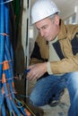 Senior worker twisting tie around bundle cable trunking