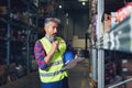 Senior worker in warehouse recording stock