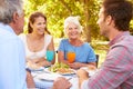 A senior and a young adult couple eating together outdoors Royalty Free Stock Photo