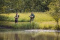 Senior and young fishermen on the river shore Royalty Free Stock Photo