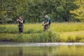 Senior and young fishermen on the river shore Royalty Free Stock Photo