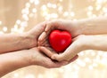 Senior and young man hands holding red heart Royalty Free Stock Photo