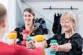 Senior and young woman with dumbbells in wireless ems gym Royalty Free Stock Photo