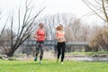 Senior and young woman running as sport on a meadow in spring or fall Royalty Free Stock Photo