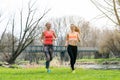 Senior and young woman running as sport on a meadow in spring Royalty Free Stock Photo