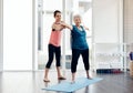 Seniors with active lifestyles experience a wealth of health advantages. a fitness instructor helping a senior woman Royalty Free Stock Photo