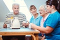 Seniors and caregivers having coffee time in the nursing home