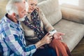 Seniors couple at home measuring blood pressure.