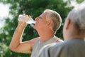 Seniors drinking water after fitness in park Royalty Free Stock Photo