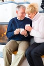 Seniors at home in front of fireplace Royalty Free Stock Photo
