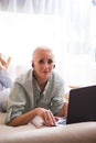 Seniors and Modern Technologies Concepts. Smiling Relaxing Caucasian Senior Woman Posing With Laptop And Listening To The Music on