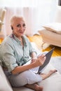 Seniors and Modern Technologies Concepts. Smiling Relaxing Caucasian Senior Woman Posing With Laptop And Listening To The Music on