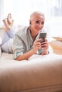 Seniors and Modern Technologies Concepts. Smiling Relaxing Caucasian Senior Woman Posing With Smartphone And Listening To The