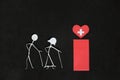 Seniors or old people access to healthcare concept. Elderly couple stick figure beside red health icon in dark black background Royalty Free Stock Photo