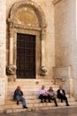 Seniors sitting at the steps of St. Nicholas Basilica, Bari, Italy