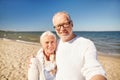 Seniors taking picture with selfie stick on beach Royalty Free Stock Photo