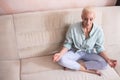 Seniors and Yoga Concepts. Portrait of Relaxing Caucasian Senior Woman Posing in Yoga Asana Pose on Couch With Closed Eyes Indoors