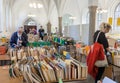 Seniors and young people reading and buying books at flea market inside historical church