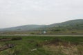 Senkvice, Slovakia - April, 2011: car moves along road near grape garden, green fields and hills view from railway carriage. Royalty Free Stock Photo