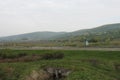 Senkvice, Slovakia - April, 2011: car moves along road near grape garden, green fields and hills view from railway carriage. Royalty Free Stock Photo