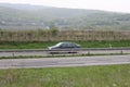 Senkvice, Slovakia - April, 2011: car moves along road near grape garden, green fields and hills view from railway carriage. Royalty Free Stock Photo