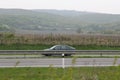 Senkvice, Slovakia - April, 2011: car moves along road near grape garden, green fields and hills view from railway carriage. Royalty Free Stock Photo