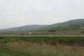 Senkvice, Slovakia - April, 2011: car moves along road near grape garden, green fields and hills view from railway carriage. Royalty Free Stock Photo