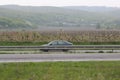 Senkvice, Slovakia - April, 2011: car moves along road near grape gardena, green fields and hills view from railway carriage. Royalty Free Stock Photo