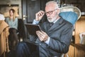 Senor businessman at cafe, using digital tablet. Royalty Free Stock Photo